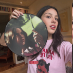 Olivia Rodrigo holding Carve Our Names vinyl artwork